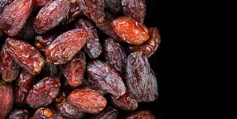 Date fruits. Dates fruit border design isolated on black background. Heap of Medjool dates close up, top view 