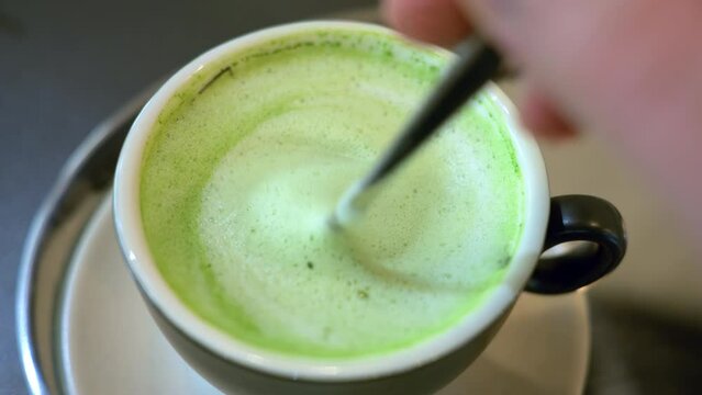 Close up green matcha latte drink on a cup