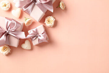 Happy Valentines Day concept. Greeting card design with gift boxes, heart shaped candles, flowers on peach fuzz color background. Top view, flat lay.