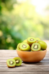 Kiwi in a bowl against the backdrop of the garden. Selective focus.