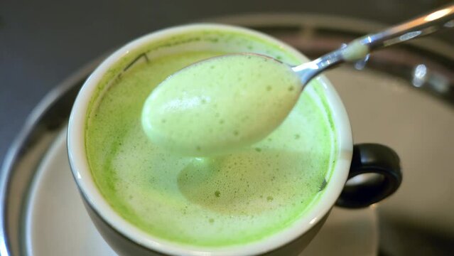 Close up green matcha latte drink on a cup