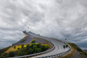 Motorcycles and cars going over the Storseisundbrua bridge Norway on a stormy day.