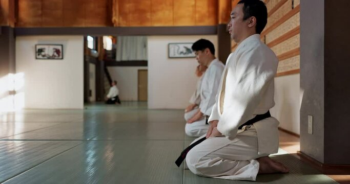 Asian man, class and bow in dojo for respect, greeting or honor to master at indoor gym. Male person or group in karate bowing on floor for etiquette, attitude or commitment in martial arts together
