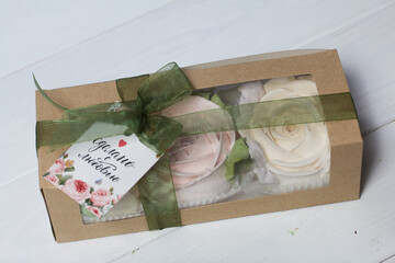 Box with homemade marshmallows. It is tied with tape. The branded tag of the entrepreneur is visible. Zephyr flowers. Roses from zephyr. A unique gift.