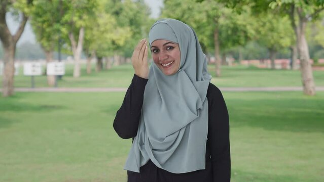 Happy Muslim woman doing Adaab in park