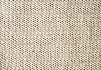 Beige knitted texture made of cotton thread.