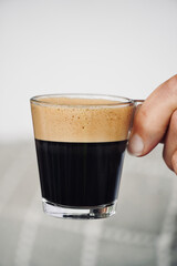 Person holding a foam coffee cup with white background and space for text.