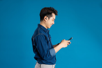 Portrait of young Asian business man posing on blue background