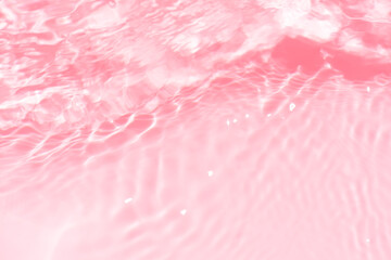 Pink water splashes on the surface ripple blur. Defocus blurred transparent pink colored clear calm water surface texture with splash and bubble. Water waves with shining pattern texture background