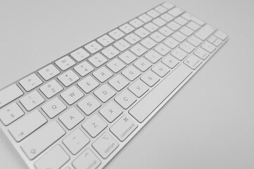 Top view of white keyboard on light grey background. Modern office flat lay, copy space.