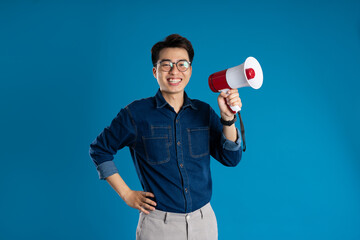 Portrait of young Asian business man posing on blue background