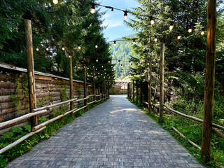 Recreation area walking road with cute garland lights above. Resort. National forest park.