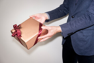 プレゼントを持つ男性の手元カット/スタジオ撮影白背景
