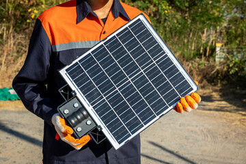 Young engineer in uniform holds solar panels for street light or in parks and parking lots which...
