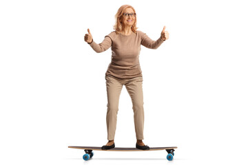 Middle aged woman riding a skateboard and gesturing thumbs up