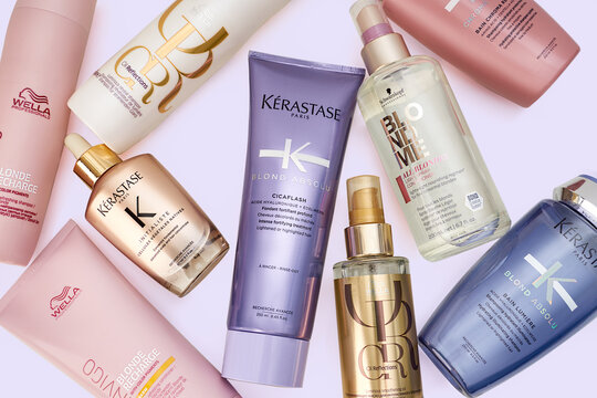 Riga, Latvia - november 20, 2023: Kerastase, Wella Professional and Schwarzkopf hair care cosmetic products on purple background, flat lay