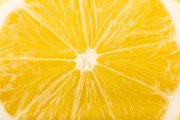 Selbstklebende Fototapeten Lemon slice close-up, yellow fruit abstract background. © RetateR