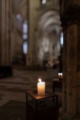 blurred interior of catholic church with  burning candle; abstract background