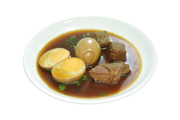 boiled half cut egg with tofu and pork in herb brown soup on plate