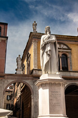 Statue of Dante Alighieri in piazza dei Signori to Verona in Italy. Springtime and holidaytime. Travel destination. White marble statue on a pedestal. Symbol of the italian culture.