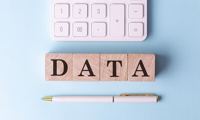 DATA on wooden cubes with pen and calculator, financial concept