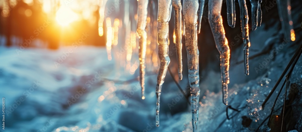 Poster melting icicles on the drainpipe against the bright sun. with copy space image. place for adding tex