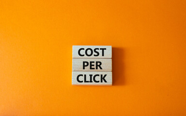 Cost Per Click symbol. Concept word Cost Per Click on wooden cubes. Beautiful orange background....