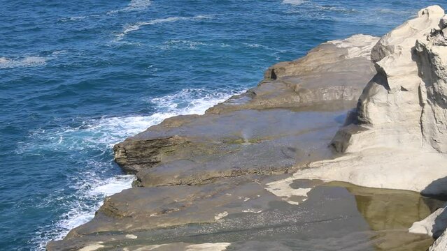 Blowhole in the middle of sea stack. Burst of seawater through rock's crack. The view of Klayar Beach at Pacitan, Indonesia