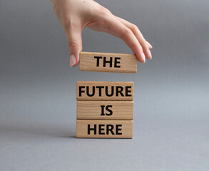 The future is here symbol. Concept words The future is here on wooden blocks. Beautiful grey background. Businessman hand. Business and The future is here concept. Copy space.