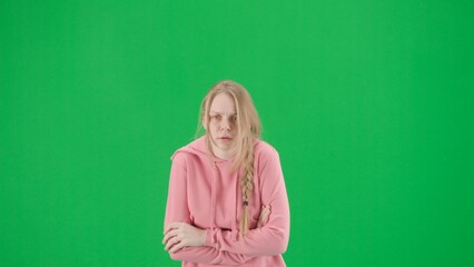 Portrait of victim on chroma key green screen background. Young girl walking, scared expression.