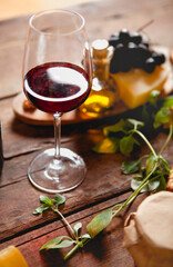 Glass of red wine with cheese and grapes