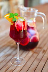 Glass of iced sangria with strawberry, orange, apple and lemon on the table.