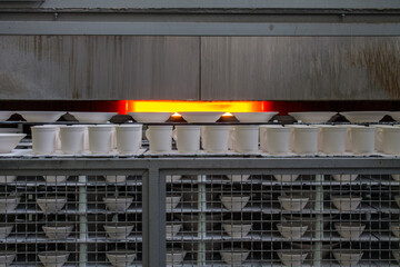 rows of white identical mugs visited in a muffle kiln at a porcelain factory in Likino-Dulevo in...