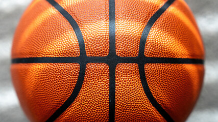 Fototapeta premium Close-up of a textured basketball surface with a clear black line, shot against a blurred grey background.