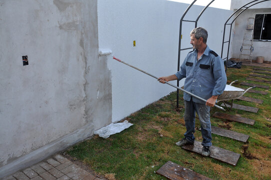 pintor trabalhando em pintura de muro 