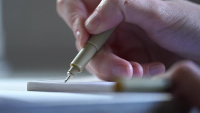 A man signs with a ballpoint pen on a white sheet of paper. Important notes. Office work. Woman hands writing on a piece of paper. Writing essay or letters. Doing homework.