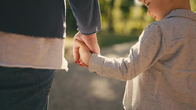 Mother and little son holding hands in park, parent child relationship, adoption