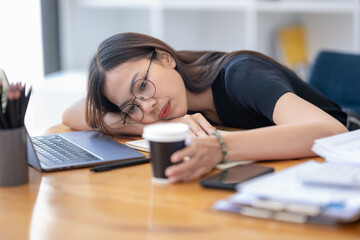 Freelance Asian businessperson, A businesswoman sits slumped on arm at her desk in a bored mood....