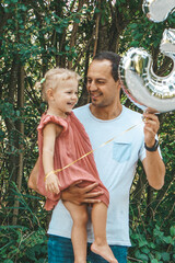 smiling father and daughter outside