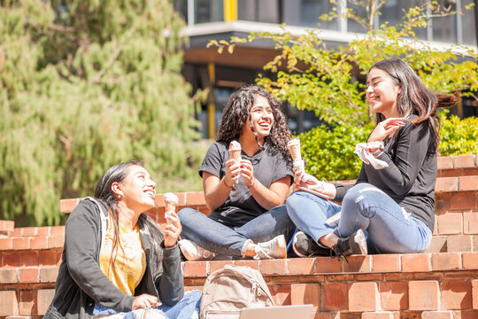 Under the sun, 3 girls enjoying a delicious cream ice cream.