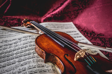 Fototapeta premium Beautiful violin and note sheets on purple background