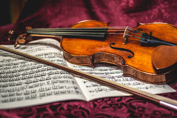 Obraz premium Beautiful violin and note sheets on purple background