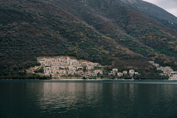 Fototapeta na wymiar Residential buildings in Kostanjica at the foot of the green mountains. Kotor Bay, Montenegro