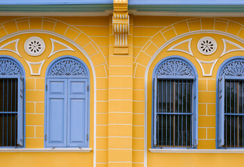 Row of blue wooden arch windows on vintage yellow building wall background, exterior architecture in street minimal style - Powered by Adobe