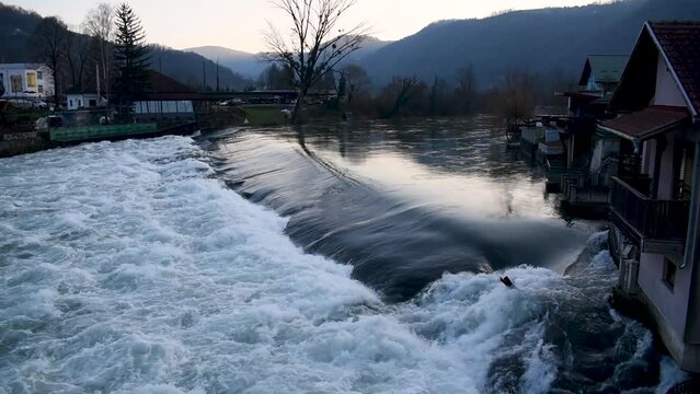 Water overflow over dam on Vrbas river, high water level, settlement Novoselija