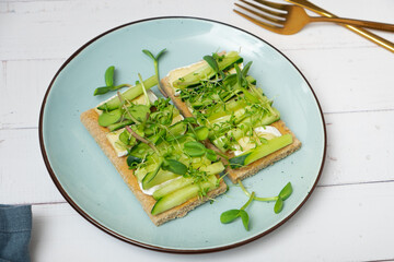 Sandwich with cheese, cucumbers and sunflower microgreens and alfalfa. Healthy eating concept.