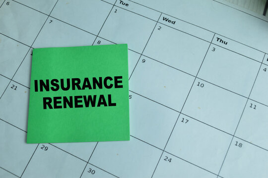 Concept of Insurance Renewal write on sticky notes isolated on Wooden Table.