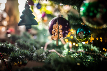Tannenbaum aus Holz als Dekoration hängt am Christbaum zu Weihnachten 