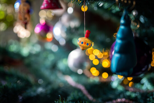 Brummkreisel aus Holz als Dekoration h&auml;ngt am Christbaum zu Weihnachten 