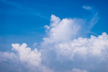 Naklejka na ściany i meble 푸른 하늘 위에 뭉게뭉게 피어나는 구름